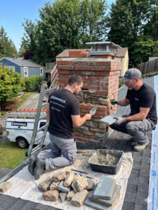 Technicians repairing brick chimney and stone veneer