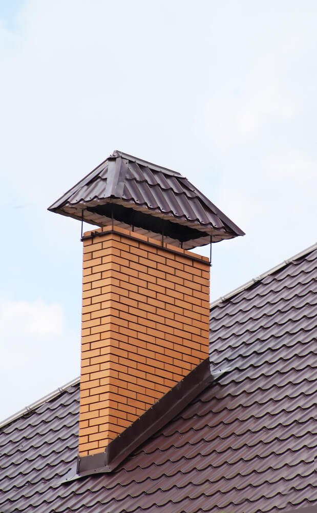 Brick chimney with metal roof cap